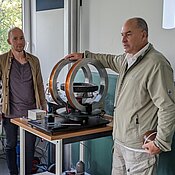 Abbildung 1: Prof. Dr. Jakob demonstriert mit seinem Assistenten anhand eines Versuchsaufbaus den Effekt der Kernspinresonanz.