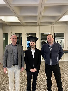 Simon Betzold mit Prof. Dr. Sven Höfling (r.) und Prof. Dr. Sebastian Klembt (l.) im Foyer der Fakultät nach dem Promotionskolloquium.