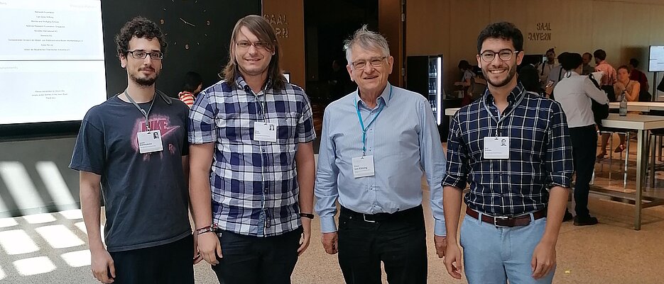 Die Doktoranden Ioannis Matthaiakakis, Tobias Müller und Raúl Stühler aus Würzburg (von links) begegnen in Lindau Physik-Nobelpreisträger Klaus von Klitzing.
