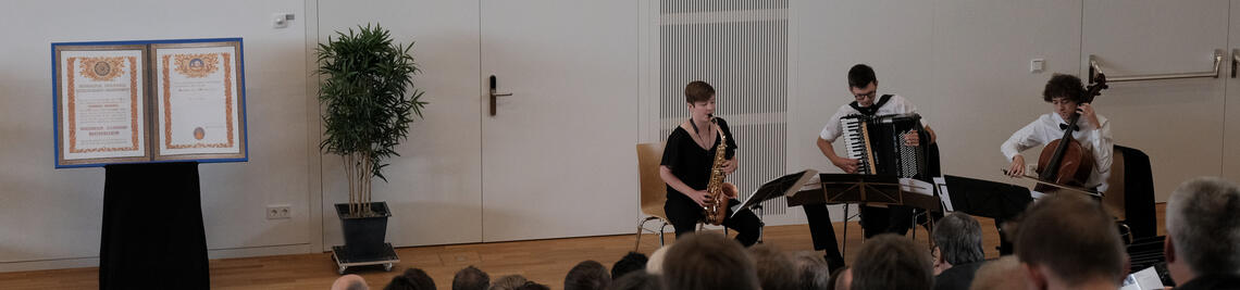 3 musicians on the stage of the lecture hall